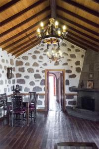 a dining room with a table and a stone wall at Casa Rural Isla de Cuba in Tejeda