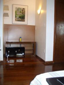 sala de estar con suelo de madera y mesa en Apartamento com Hidro en Belo Horizonte
