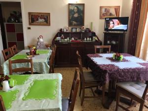 a dining room with two tables and a tv at B&B Amelia in Pescara