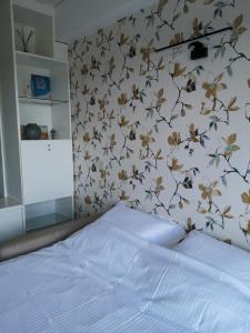 a bedroom with a bed with a floral wall at Zeester en koffie. in Oostduinkerke-Bad