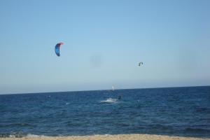 a person kite surfing in the ocean on the beach at Apartamento Augusta Cambrils Lux con vista al mar in Cambrils