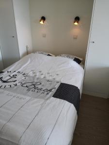a bedroom with a bed with a white comforter at Zeester en koffie. in Oostduinkerke-Bad +29 photos