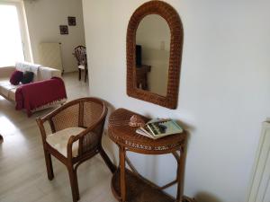 Zimmer mit einem Tisch, einem Spiegel und einem Stuhl in der Unterkunft Panorama View Apartment 1 in Áyioi Apóstoloi