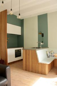 uma cozinha com paredes verdes e brancas e um balcão em Bij Isa & Max em Kampen