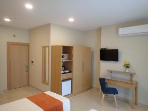 a bedroom with a bed and a desk and a television at Duncan Guesthouse in Marsaxlokk