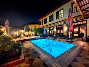 een zwembad voor een gebouw 's nachts bij Eski Masal Hotel - Special Class in Antalya