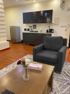 a living room with a couch and a table with flowers at لوفا للشقق المخدومة in Yanbu