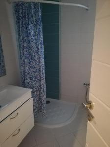 a bathroom with a shower with a blue shower curtain at Costa Marina 212 in Hammamet