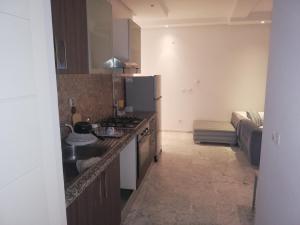 a kitchen with a sink and a refrigerator in a room at Costa Marina 212 in Hammamet