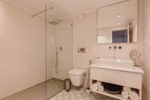 a white bathroom with a sink and a shower at Hidden Gem in Principe Real in Lisbon