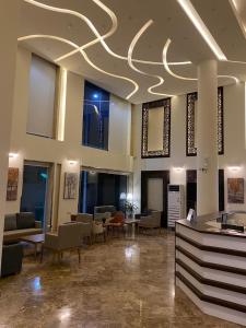 a lobby with couches and chairs in a building at Lova Suites in Yanbu