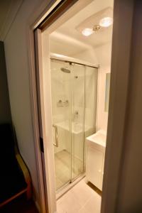 La salle de bains est pourvue d'une douche en verre et d'un lavabo. dans l'établissement Junee Tourist Park, à Junee