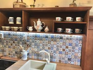 a kitchen with a sink and a tiled wall at Apartmány ReMi Vysoké Tatry in Dolný Smokovec