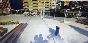 a empty courtyard with tables and chairs and umbrellas at APARTAMENTO HUESCA in Huesca