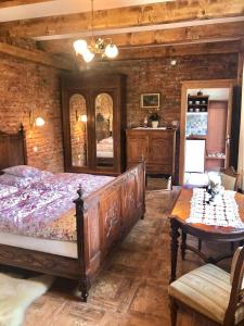 a bedroom with a large wooden bed and a table at Apartmány ReMi Vysoké Tatry in Smokovce