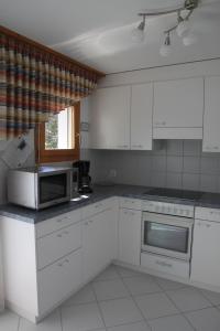 a kitchen with white cabinets and a microwave at Moutain View in Laax