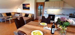 sala de estar con sofá y mesa con copas de vino en Alpine Lodge Wertach en Wertach