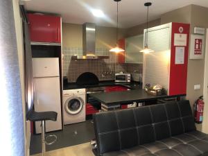 プラセンシアにあるLa Capital del Jerteのキッチン(赤いキャビネット、洗濯機、乾燥機付)