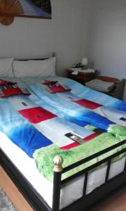 a large bed with a colorful blanket on it at Wikingerstadt 1 in Schleswig