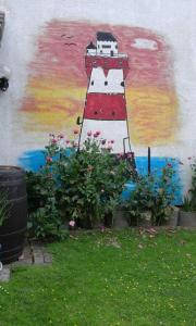 a painting of a lighthouse on the side of a wall at Wikingerstadt 1 in Schleswig