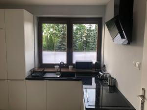 kuchnia ze zlewem i oknem w obiekcie Klimatyzowane Apartamenty i Pokoje przy Targach Kielce w Kielcach