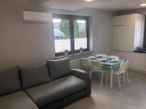 sala de estar con sofá y mesa con sillas en Klimatyzowane Apartamenty i Pokoje przy Targach Kielce en Kielce