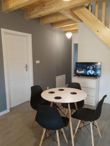 a dining room with a table and chairs and a tv at Domek Bobrowe Zacisze 2 in Karpacz