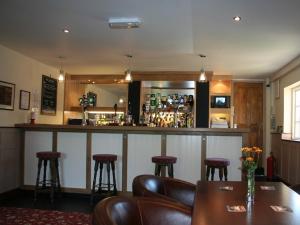 a bar in a restaurant with leather chairs and a table at The Lord Nelson Inn in Newark-on-Trent