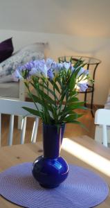 a blue vase with purple flowers on a table at U Václava in Kněževes
