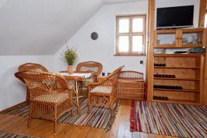 uma sala de jantar com uma mesa e cadeiras de vime em Troszt Pince Apartman em Villány