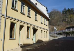a yellow building on the side of a street at Pension zum Hirschstein in Greiz