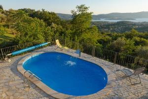 a blue swimming pool with a fence around it at Sunset Holiday Home in Tivat