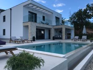 uma casa com uma piscina em frente em Villa Askim Prestige em Opatija