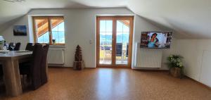 a living room with a table and a tv on the wall at Alpine Lodge Wertach in Wertach