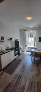 a kitchen with white cabinets and a wooden floor at Opatija Center Apartments in Opatija