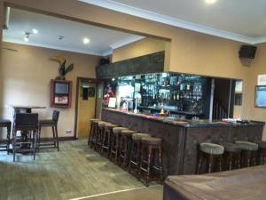 a bar in a restaurant with bar stools at Macbeth Arms in Lumphanan