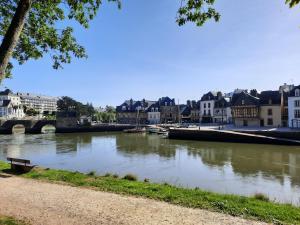 un río en una ciudad con edificios y un puente en Appartement Port de St Goustan en Auray