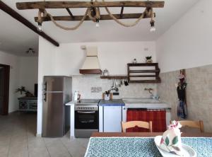 a kitchen with a stove and a refrigerator and a table at A me ca picita in Stella