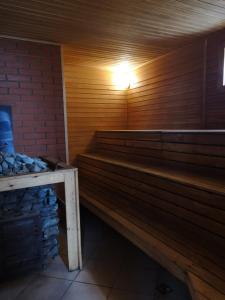 eine Holzbank in einer Sauna mit Licht darauf in der Unterkunft Abromiškių Sodyba in Elektrėnai