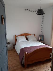 een slaapkamer met een groot bed met een houten hoofdeinde bij La Parenthèse in Folles