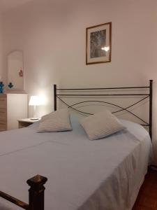 a bedroom with a large white bed with two pillows at Terrazza sul Mare holidays with experiences in Lipari