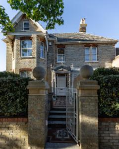 uma casa de tijolos com um portão e uma cerca em Cranborne House em Poole