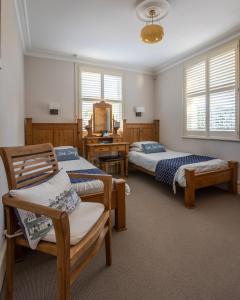 a bedroom with two beds and a table and chairs at Cranborne House in Poole