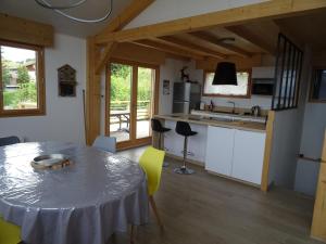 cocina y comedor con mesa y sillas en Chalet neuf 6 personnes, en Mont-Saxonnex