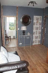 een woonkamer met een bank en een tafel met een lamp bij La Parenthèse in Folles
