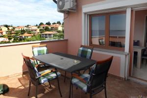 een zwarte tafel en stoelen op een balkon met uitzicht bij Apartmaji ORKO s pogledom na morje - Sea View Apartments ORKO in Portorož +59 foto's