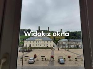 a view of a building with cars parked in a courtyard at Apartament na Rynku in Chęciny
