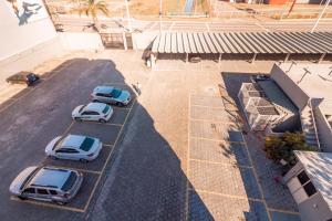 drei Autos auf einem Parkplatz neben einem Gebäude geparkt in der Unterkunft Hotel Kennedy in São José