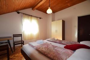 a bedroom with two beds and a desk and a window at Apartment Škeva in Starigrad