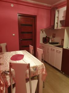 a kitchen with a table and a table and chairs at Kolibri 2 vendèghàz in Mórahalom